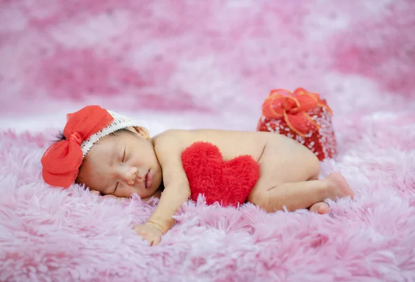 Beautiful cute baby with heart pillow — Stock Photo, Image