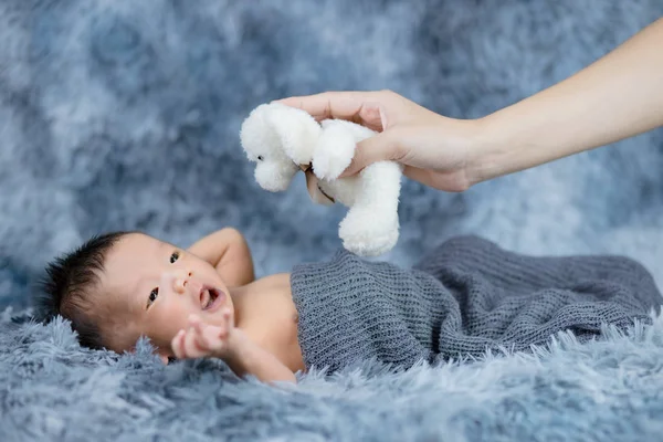 Mother holding a toy to little baby — 图库照片