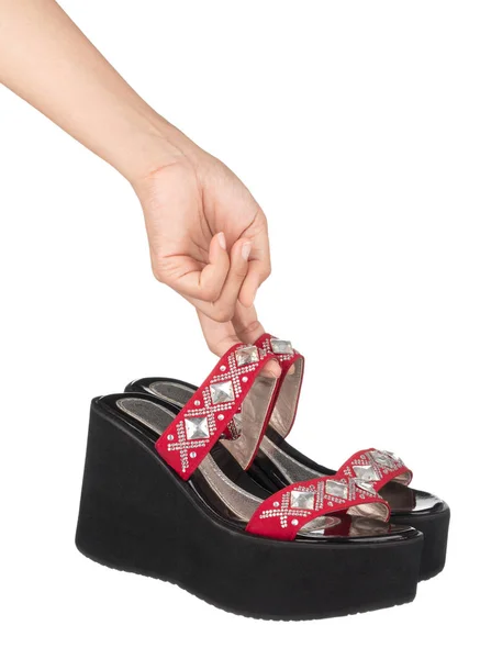 Hasnd holding vrouwelijke wig hakken schoenen sandalen op platform met — Stockfoto
