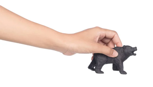 Рука тримає пластиковий іграшковий ведмідь ізольований на білому тлі — стокове фото