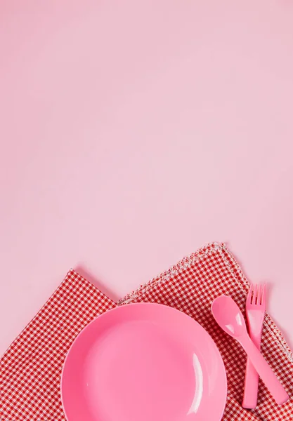 Pink color plastic plate with plastic spoon, fork and cloth napk