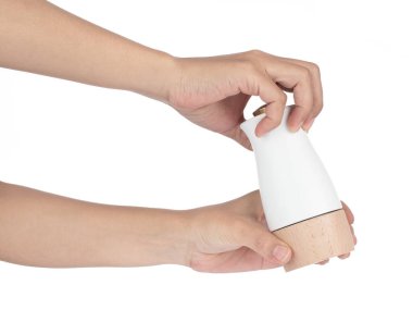 Hand holding wooden bottles condiment isolated on white backgrou