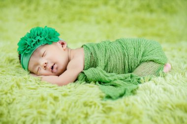 Yün halılarda çiçek bandı takan şirin Yenidoğan 'ı kapat.