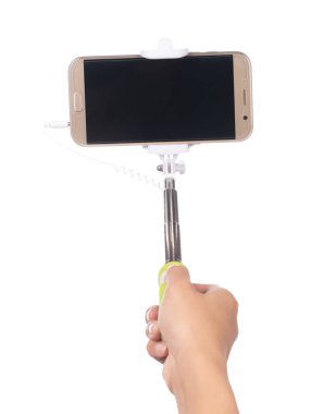 hand holding selfie stick with  mobile phone isolated on a white