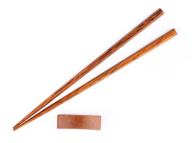 pair of wood chopsticks with wood holder isolated on a white bac