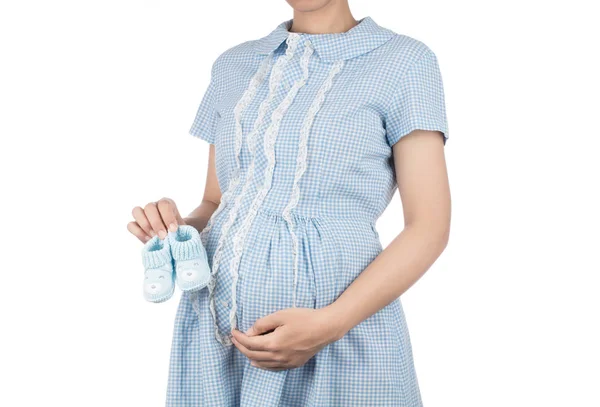 Těhotná žena v modré košili šaty drží dítě háčkovat boty je — Stock fotografie