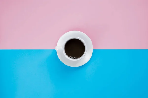 Black coffee in white cup on pink and blue background — 图库照片