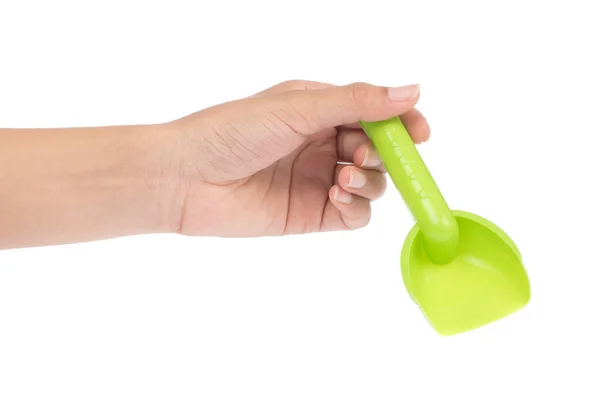 Mano sosteniendo pequeña pala de juguete de plástico aislado en un fondo blanco — Foto de Stock