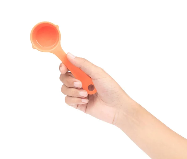 Hand holding orange plastic scoop isolated on white background — Stock Photo, Image