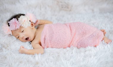 Yün halılarda çiçek bandı takan şirin Yenidoğan 'ı kapat.