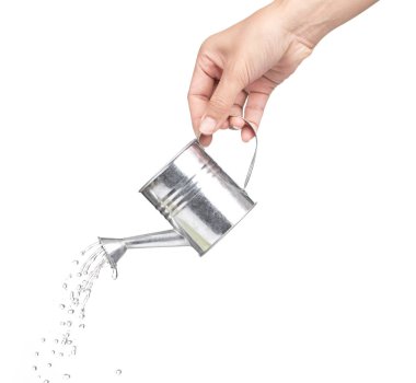 hand holding a small metal watering can with spout isolated on w