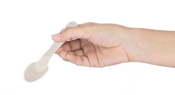 Ținând mâna lingura de plastic biodegradabil izolat pe spate alb — Fotografie, imagine de stoc