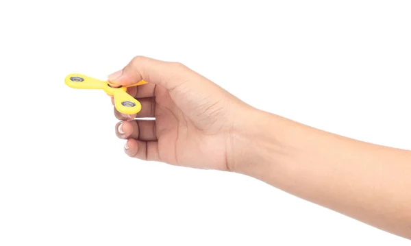 Fingers playing a yellow fidget spinner isolated on a white back — 图库照片
