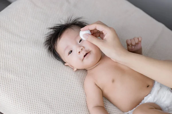 Gros plan de la mère Nettoyage des yeux de bébé. — Photo