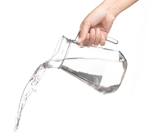 Hand pouring water from glass jug to glass isolated on a white b