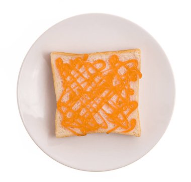 Beyaz arka planda portakal reçelli bir tabak ekmek.