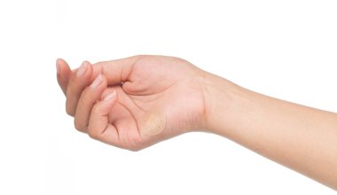 Yaralanma üzerinde el yapıştırıcı bandajları göster. Beyaz arka planda eller.