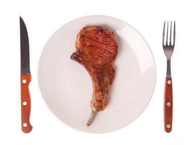 Izgara domuz kaburgası. Çatal ve bıçakla birlikte beyaz arka planda.