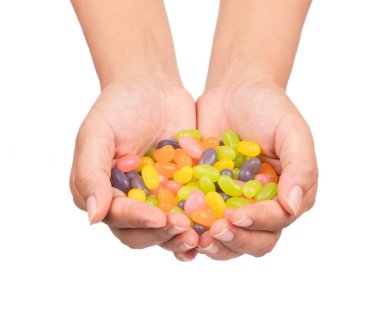 El ele tutuşan jöleli şekerler beyaz arka planda izole edilmiş.