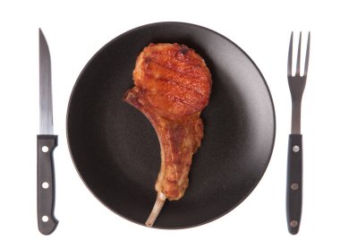 Izgara domuz kaburgası. Çatal ve bıçakla birlikte beyaz arka planda.