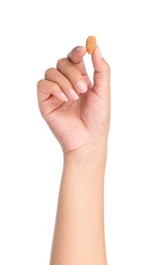 Beyaz arkaplanda izole edilmiş badem tohumunu tutan parmaklar