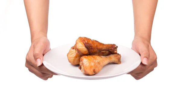 手を握って白い背景に隔離された皿の上に鶏の足をロースト — ストック写真