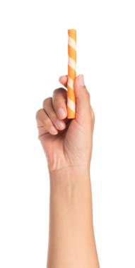 El ele tutuşan çizgili gofret ruloları beyaz arka planda portakalla izole edilmiş.