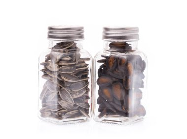 Beyaz arka planda izole edilmiş karpuz çekirdekleri ve güneş çiçeği tohumları.