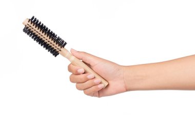 Beyaz bir arka planda el ele tutuşan ahşap saç tarağı.