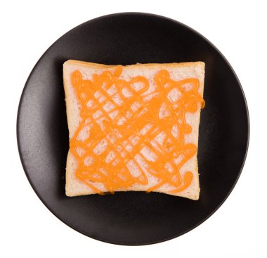 Beyaz arka planda portakal reçelli bir tabak ekmek.