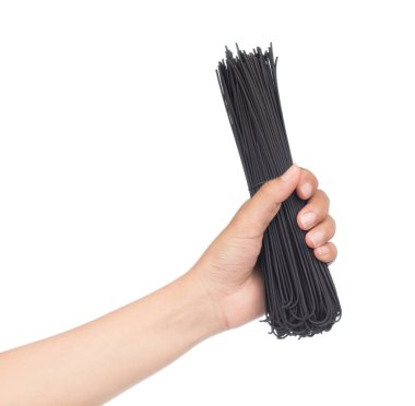 El ele tutuşmamış siyah spagetti beyaz arka planda izole edilmiş..