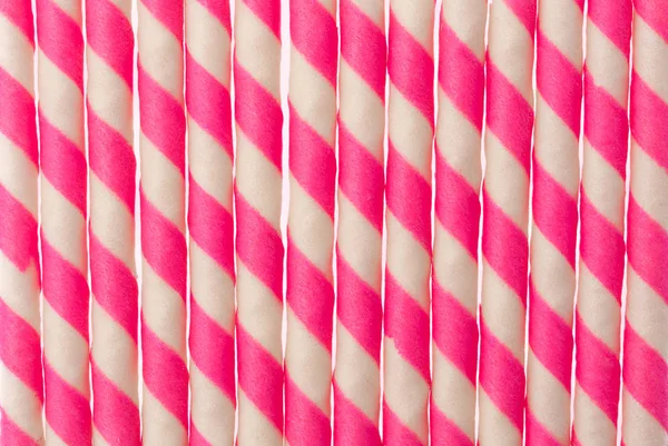 background of Striped wafer rolls filled with strawberry