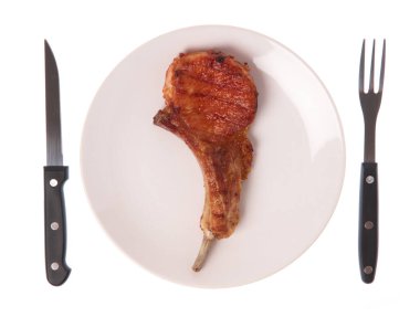Izgara domuz kaburgası. Çatal ve bıçakla birlikte beyaz arka planda.