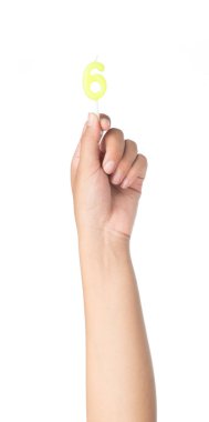 El ele tutuşan altı numaralı mum beyaz arka planda izole edilmiş.