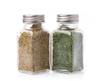 Bir şişe maydanoz ve kekik çeşnisi beyaz arka planda izole edilmiş..