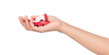Beyaz arka planda izole edilmiş plastik poşette çikolata şekerlemeleri tutan el.