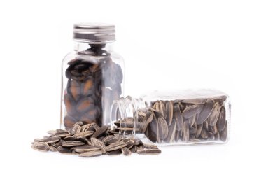 Beyaz arka planda izole edilmiş karpuz çekirdekleri ve güneş çiçeği tohumları.