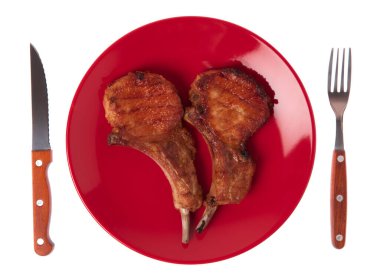 Izgara domuz kaburgası. Çatal ve bıçakla birlikte beyaz arka planda.