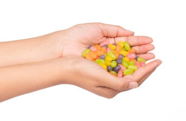 El ele tutuşan jöleli şekerler beyaz arka planda izole edilmiş.