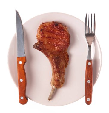 Izgara domuz kaburgası. Çatal ve bıçakla birlikte beyaz arka planda.