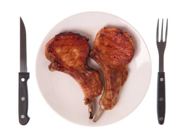 Izgara domuz kaburgası. Çatal ve bıçakla birlikte beyaz arka planda.