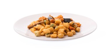 Beyaz arka planda izole edilmiş tabakta pirinç kraker, fındık ve kurutulmuş balık karışımı.