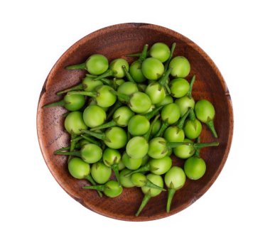 Beyaz arka planda izole edilmiş ahşap tabakta biraz patlıcan veya hindi üzümü.