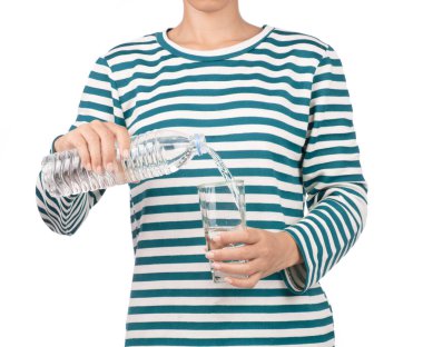 Uzun kollu gömlekli kadın beyaz arka planda izole bir şekilde şişeden su döküyor.