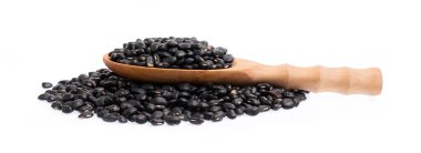 Fasulye yığınında kepçeli siyah fasulyeler beyaz arka planda izole edilmiş.