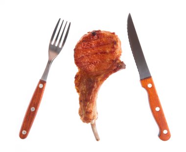 Beyaz arka planda ızgara domuz kaburgası ve çatal ve bıçak.