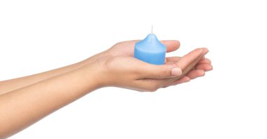 El ele tutuşan mavi mum beyaz arkaplanda izole edilmiş.