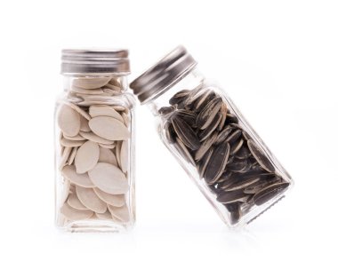 Beyaz arka planda izole edilmiş balkabağı çekirdekleri ve güneş tohumu.