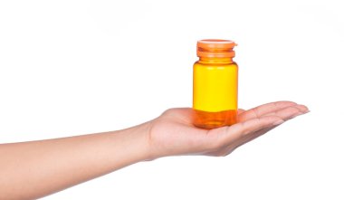 El ele tutuşan boş turuncu ilaç şişesi beyaz arka planda izole edildi