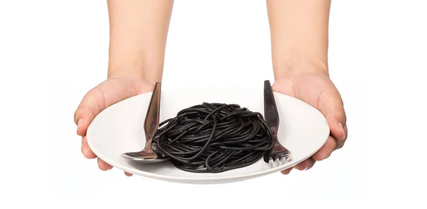 Hand Hålla Platta Med Svart Spaghetti Pasta Isolerad Vit Bakgrund — Stockfoto
